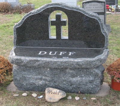A normal sized headstone shaped like a bench