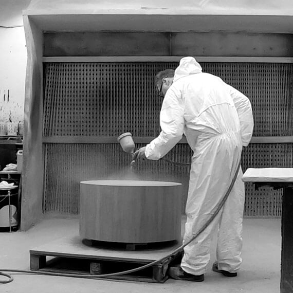 Man  in protective clothing, spraying  wooden table