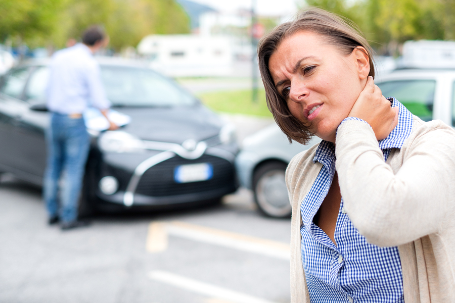 Una mujer se lamenta de su dolor de cuello después de un accidente de auto