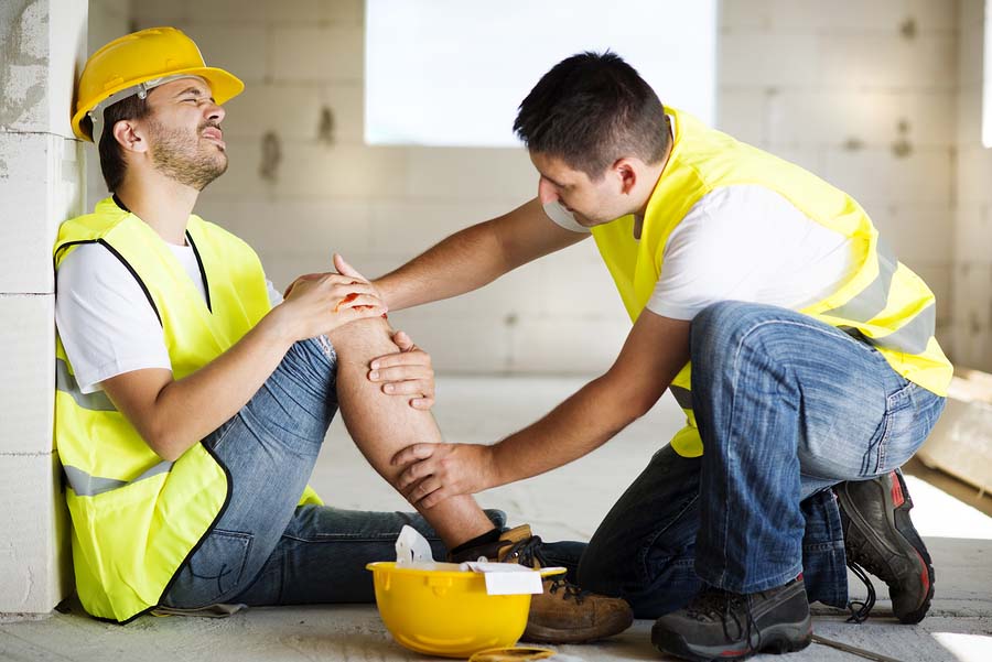 Un trabajador está ayudando a otro trabajador lesionado en un accidente de trabajo 