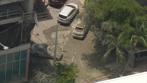 Autos cubiertos de concreto después de un accidente de construcción en Miami Beach