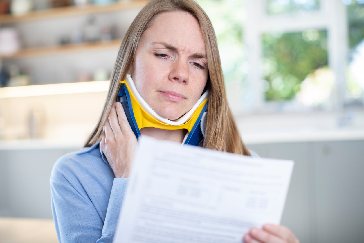 Una mujer lesionada en el cuello leyendo un documento