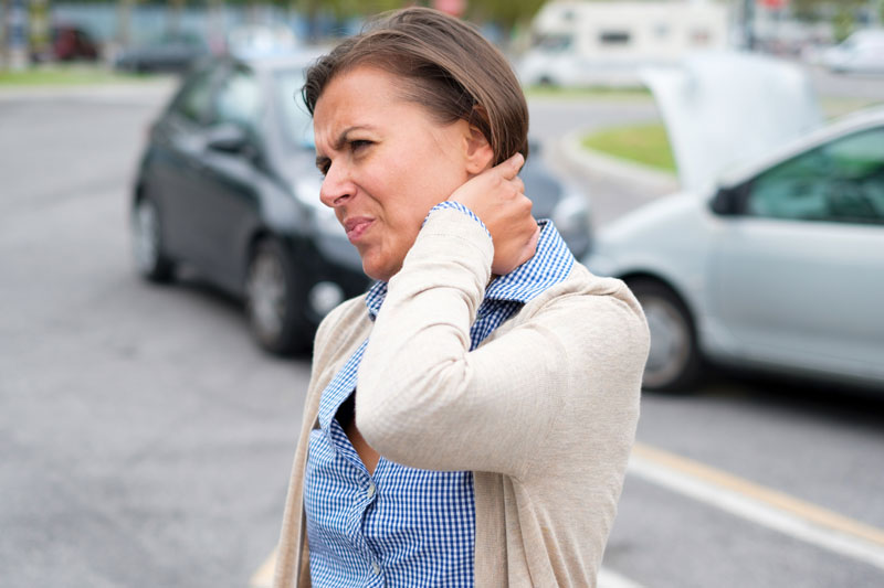 Una mujer con molestias en el cuello después de un accidente de auto