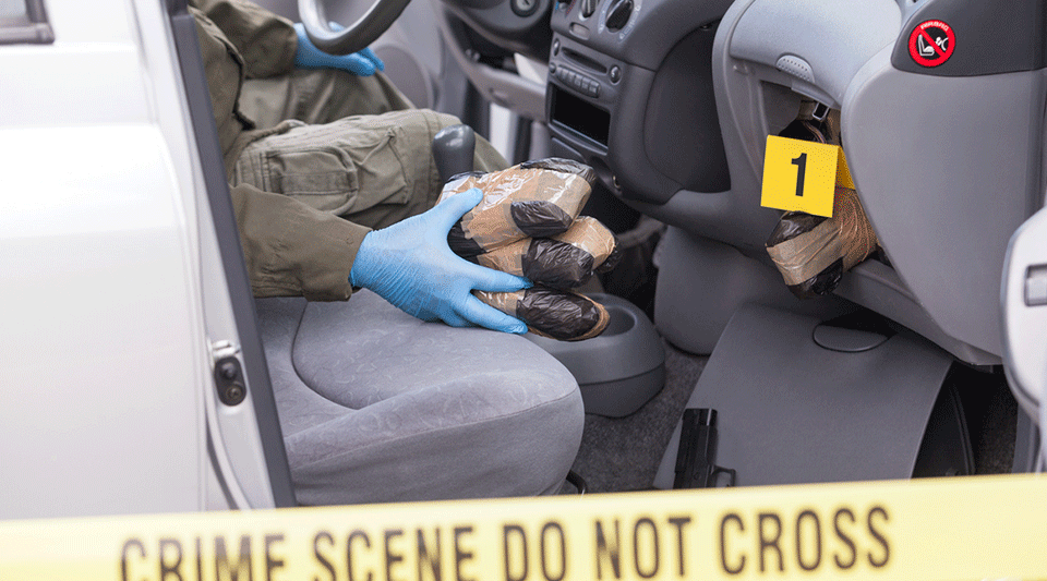 Un policía encontrando drogas escondidas en un vehículo